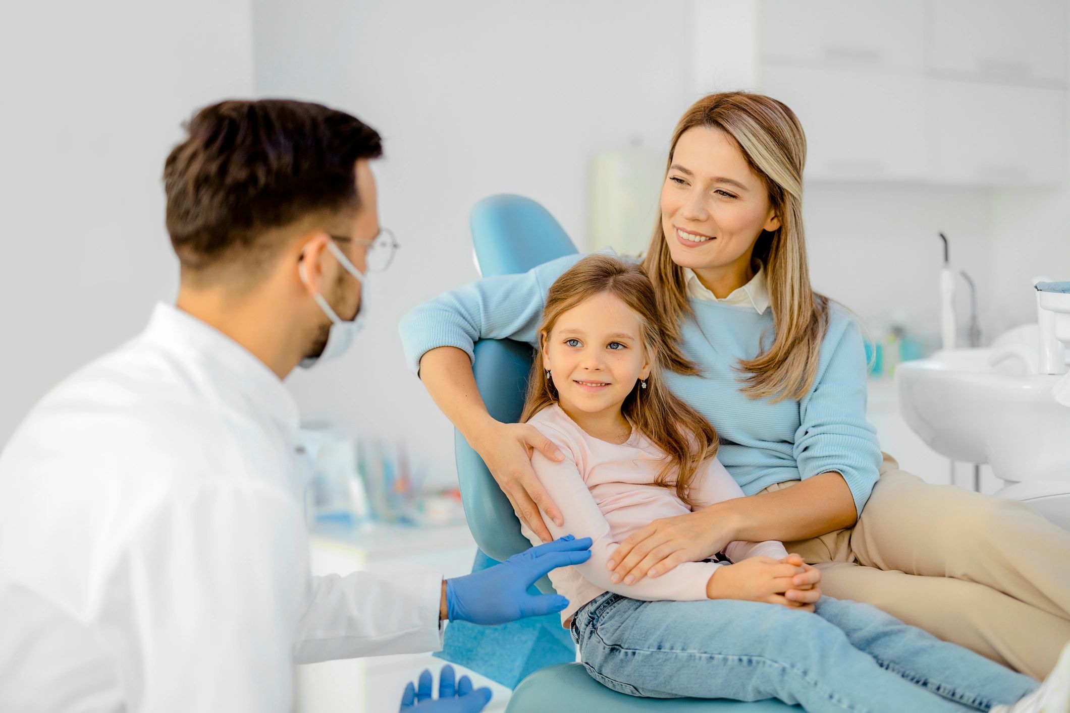 Dentist speaking with a parent and child in clinic
